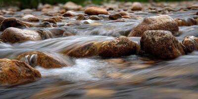 Water flows around rocks in small mountain stream during daytime photo