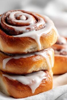Stack of three Cinnamon Rolls with White Frosting Drizzled photo