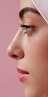 Woman in headscarf with makeup on pink background photo