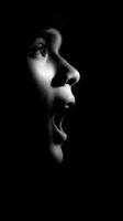 Person screaming in the dark black and white portrait photo