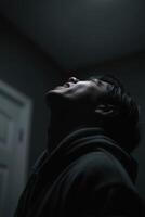 Low angle of Man looking up in dark indoor space photo
