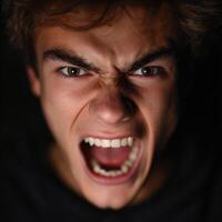 Teen boy expresses anger and frustration with open mouth photo