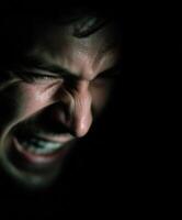 Intense close-up of angry Man's face in the Dark photo