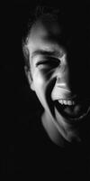 Man's face laughing in grayscale with bright teeth photo