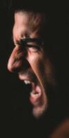 Man screaming in darkness showing powerful intense emotion photo