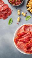 Appetizers of salami, nuts and peppers on a table ready to be enjoyed in a light atmosphere photo