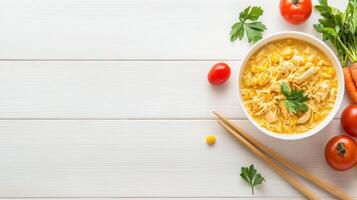 Bowl of chicken and corn soup with tomatoes on wood, top view, for menu or recipe photo