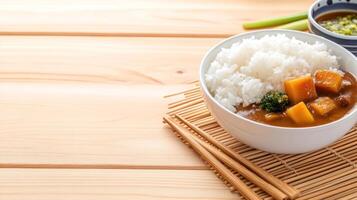 Bowl of curry rice on a mat. Warm lunch on wood background. Possible food blog or menu use photo