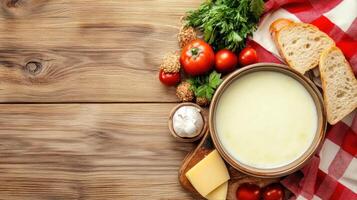 Cheese fondue with bread on rustic wood table. Warm, savory meal at home. Dinner party menu photo