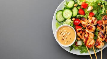Chicken skewers with salad and sauce on a plate for lunch or dinner, on grey background photo