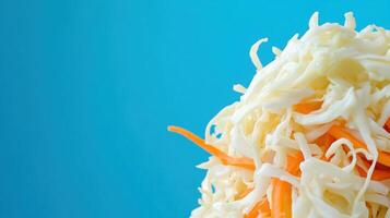 Colorful salad of shredded cabbage and carrots on blue backdrop. For restaurant menu photo