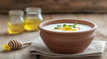 Creamy porridge with honey and flower on the table, rustic setting, healthy breakfast idea photo