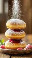 Donuts with raspberry jam stacked, dusted with icing sugar, rustic wood background photo
