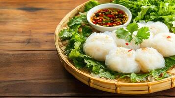 Dumplings served with sauce and herbs in a basket on a wooden table for restaurant menu photo