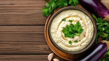 Eggplant dip with parsley. Baba Ghanoush appetizer presentation on a wooden surface. Use Cooking blog photo
