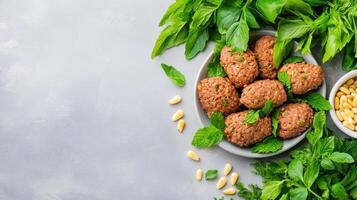 Falafel balls with basil and pine nuts on a grey background, ideal for food bloggers and menus photo