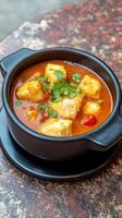 Fish Stew Dish a black bowl of fish stew with parsley garnish on a marble table, for menu visuals photo