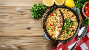 Fish stew with garnish. Lemons and tomatoes in background. Display ad for food blog photo