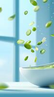 Green okra slices are falling into a white bowl in a bright, soft and minimalist environment photo