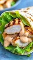 Grilled chicken wrap with salad on a table, close-up, shot in daylight. Possible healthy food photo