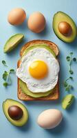 Healthy breakfast fried egg and avocado on toast, with greens, on a blue background. For editorial use photo