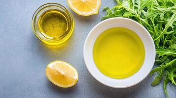 Ingredients Oil in bowls with lemons, and arugula on a grey background, for cooking, recipe, and diet photo