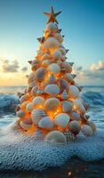 Seashell tree at sunset. A unique tree made of seashells glows with lights by the shoreline as waves crash against the sand during sunset. photo