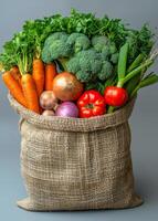Fresh veggies in burlap sack. A burlap sack filled with various fresh vegetables, showcasing vibrant colors and natural textures. photo