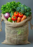 Fresh vegetables in a burlap sack. A burlap sack filled with assorted fresh vegetables including broccoli, tomatoes, carrots, and celery. photo