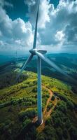 Turbine above green landscape. A towering wind turbine stands against a backdrop of rolling hills and green fields under a partly cloudy sky. photo