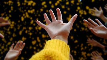 Hands reaching up in celebration, surrounded by floating yellow petals in a vibrant display of joy and enthusiasm photo
