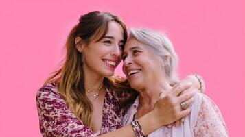 Two women enjoy a joyful moment together against a vibrant pink background in a sunny outdoor setting photo