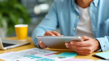 Professional analyzing business reports while using tablet in a bright and organized workspace during the day photo