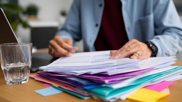 Organizing paperwork and managing tasks at a work desk in a home office setting during daylight hours photo