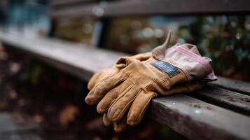 Work gloves resting on a wooden bench in a serene park during autumn photo
