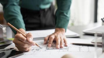 a Engineer is working on a blueprint with a pencil photo