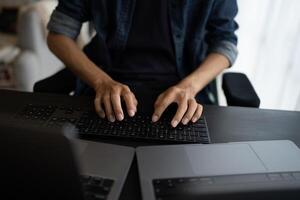 Asian man software engineer Working on Computer at office desk for writing program IT Software Engineer finding errors tech support devops creating digital photo