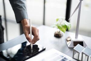 businessman using tablet and pen to draw on paper and laptop photo