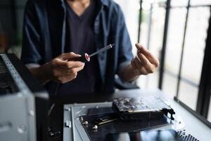 a man is working on a computer with a screwdriver photo