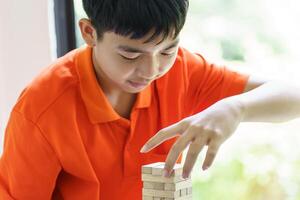 Asian father and son playing wood blocks game Carefree kid playing wood blocks game building constructor from blocks with father photo