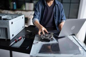 a man working on a laptop computer with a broken motherboard photo