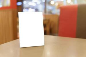 Mock up Menu frame standing on table in restaurant space for text photo