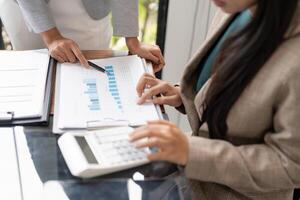 two business people are working on a document with a calculator photo