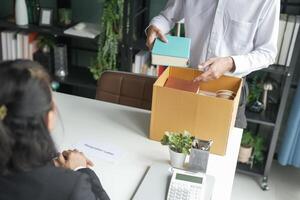 Businessman sending resignation letter and packing Stuff Resign Depress or carrying business cardboard box Change of job or fired from company resign. photo