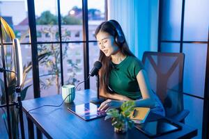 Content creator woman influencer creating content in home studio entertainment and communication blogger vdo record with smartphone for online vlog photo