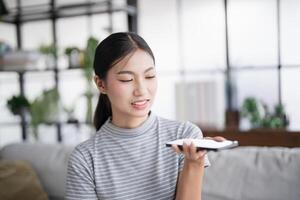 Asianwoman using voice assistant on smartphone conversation with online assistant Voice chat bot conversational AI Modern Technologies. photo