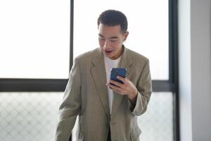 Asian businessman holding Smartphone working mobile devices. cell telephone technology ecommerce smartphone for business photo