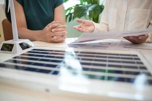two people sitting at a table with a solar panel photo