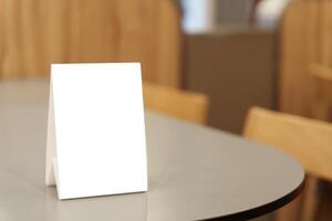 Mock up Menu frame standing on wood table in restaurant space for text photo