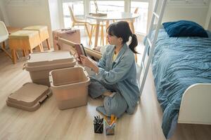 Student sitting on the floor with boxes and unpacking photo